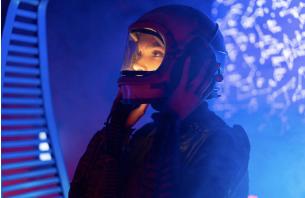 Foto de menina vestida de astronauta, tirando o capacete em close